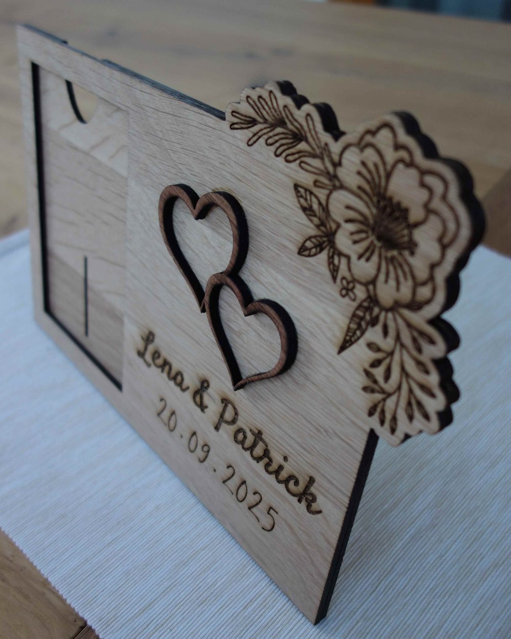 Bilderrahmen aus Holz zur Hochzeit mit zwei Herzen, Blumenranke und der Gravur „Lena & Patrick 20.09.2025“
